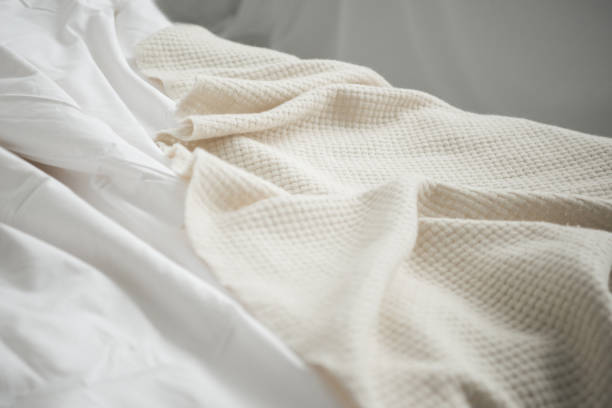 istock Close up of cozy empty bed with white blanket and sheets 1144867648