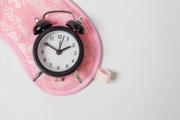 istock Sleeping mask and alarm clock on white background 1144868680