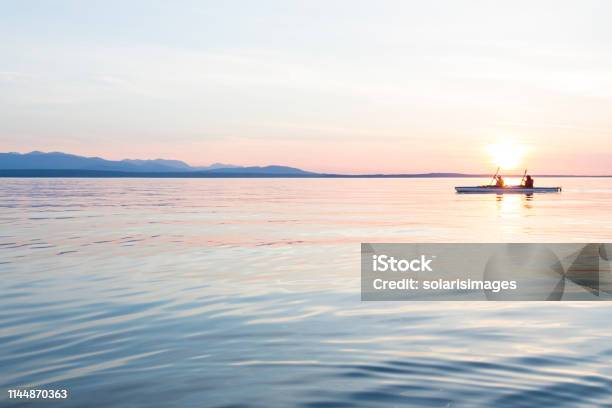 People Women Sea Kayaking Paddling Boat In Calm Water Together At Sunset Active Outdoor Adventure Water Sports Journey Destination Teamwork Concepts Stock Photo - Download Image Now