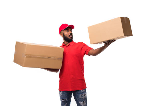 istock Happy smiling indian delivery man carrying boxes isolated on white background 1144872460