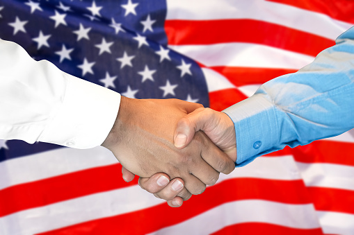 Business handshake on american flag background. Men shaking hands and American flag on background. Support concept