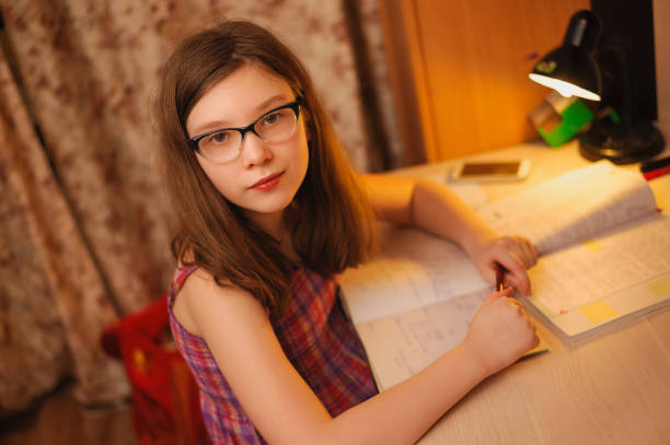 istock girl with glasses doing evening lessons 1144873984