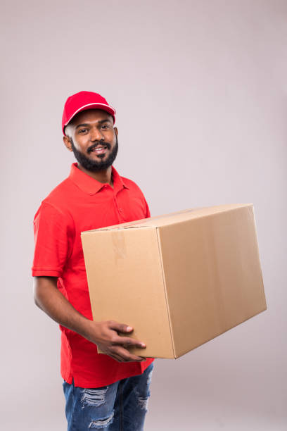 istock Side view of indian delivery man with box in studio. isolated gray background 1144874053