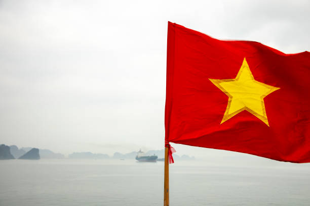 Vietnamese flag overlooking  Ha Long Bay, Vietnam through haze of pollution.