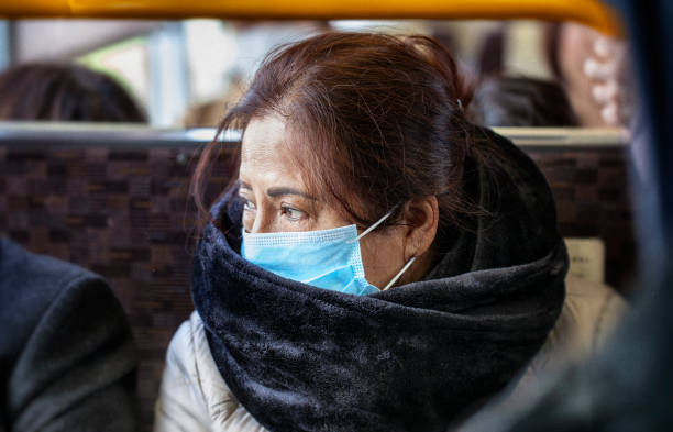 Older Asian woman wearing black fur scarf and surgical pollution mask sitting on a bus Older Asian woman wearing black fur scarf and surgical pollution mask sitting on a bus mink fur stock pictures, royalty-free photos & images