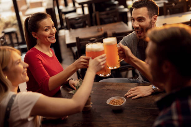 istock Group of cheerful friends toasting with beer in a pub. 1144879663