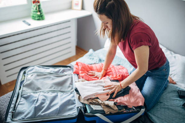 istock Young woman packing suitcase 1144880924
