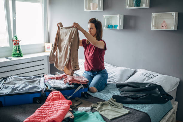 istock Young woman packing suitcase in her bedroom 1144881306