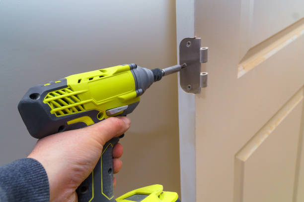 istock Hands screwing hinge on wooden door with screwdriver 1144891910