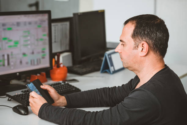 istock Male Engineer is with the Phone in his Office 1144896387