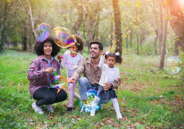 istock Happy family playing soap bubbles in park. 1144909097
