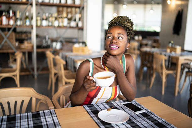 istock Young african woman drinking coffee in bar 1144910978