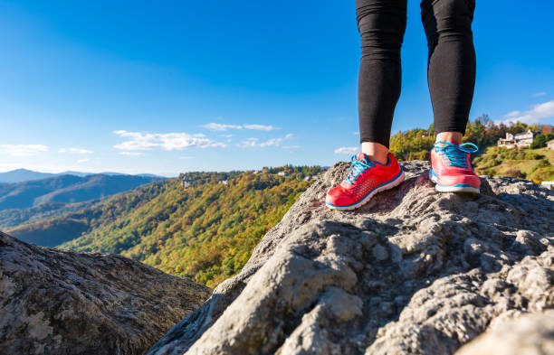 Woman standing at the edge of a cliff high above the mountains