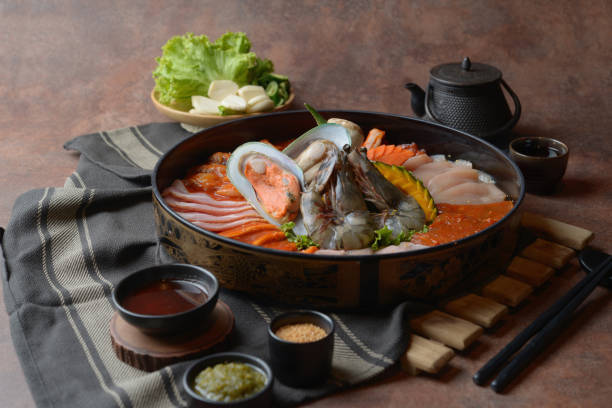 istock Side of beef garnished with sesame, and shellfish with prawns arranged on the tray combined with vegetables for grill set on the table. 1144926598