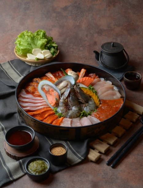 istock Side of beef garnished with sesame, and shellfish with prawns arranged on the tray combined with vegetables for grill set on the table. 1144926893