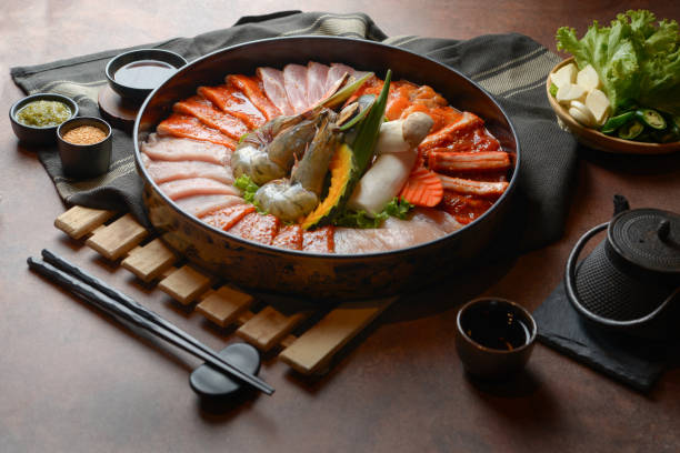 istock Side of beef garnished with sesame, and shellfish with prawns arranged on the tray combined with vegetables for grill set on the table. 1144927594