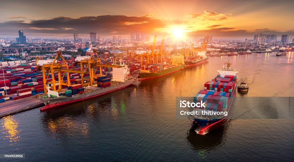 Logistics and transportation of Container Cargo ship and Cargo plane with working crane bridge in shipyard at sunset, logistic import export and transport industry background Freight Transportation Stock Photo