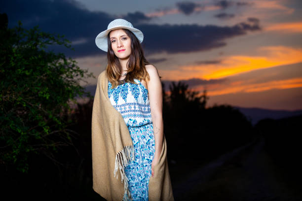 Portrait of young woman at sunset, where incredible colors like red and orange stand out. Posing in front of the camera.