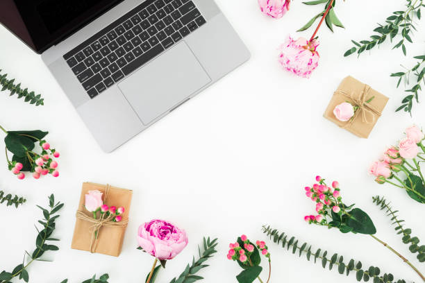 istock Office workspace with laptop and pink flowers on white background. Top view. Flat lay. 1144947783