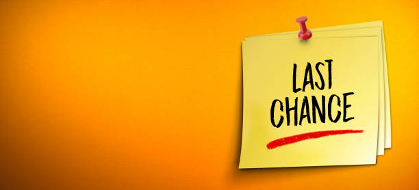 Yellow stick note paper on the orange wall with last chance message in large copy space