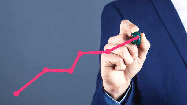 istock businessman with a marker draws a growing arrow on the screen 1144949498