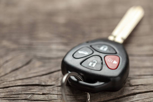 istock Car keys with remote control alarms on wooden background. 1144951907