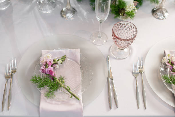 istock Closeup Table setting with plates and tableware, adorned with flowers. Floral decoration for wedding ceremony romance dining. Wedding banquet , festive decor. Concept of service and catering. 1144952624