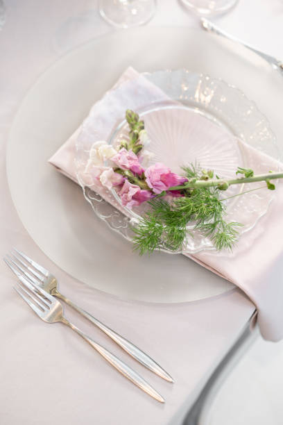 istock Closeup Table setting with plates and tableware, adorned with flowers. Floral decoration for wedding ceremony romance dining. Wedding banquet , festive decor. Concept of service and catering. 1144953134