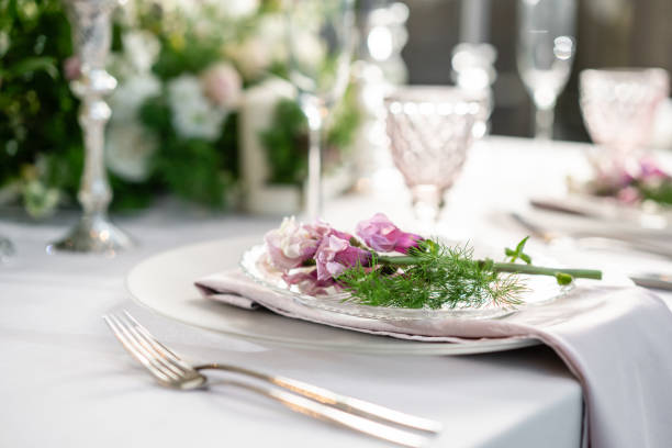 istock Closeup Table setting with plates and tableware, adorned with flowers. Floral decoration for wedding ceremony romance dining. Wedding banquet , festive decor. Concept of service and catering. 1144953265