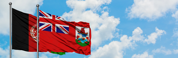 Afghanistan and Bermuda flag waving in the wind against white cloudy blue sky together. Diplomacy concept, international relations.