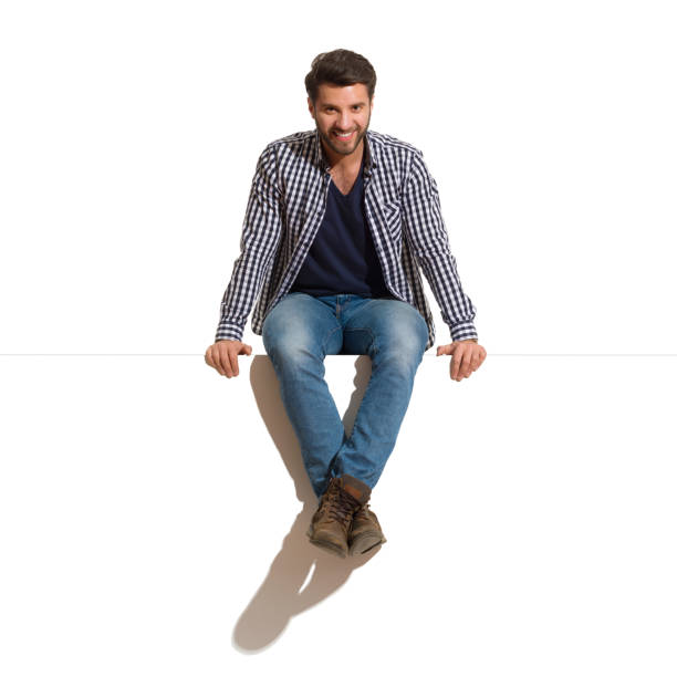 istock Smiling Handsome Man Is Sitting On A Top Of White Banner 1144957338