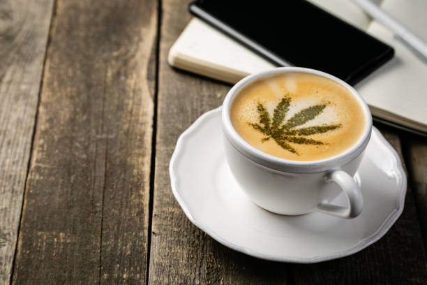 café de cannabis-feuille de marijuana sur la mousse de café - leaf cup breakfast drink photos et images de collection