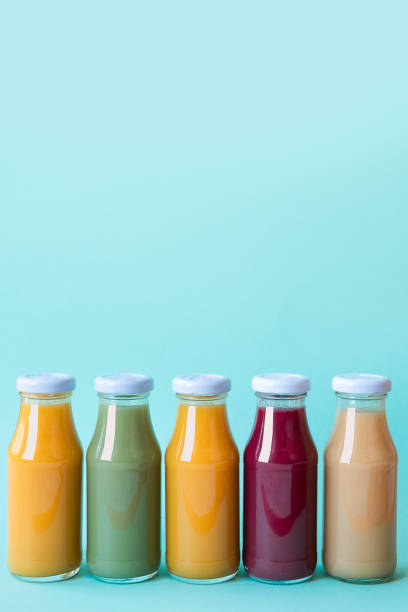istock Raw vegetable and fruit juices in glass bottles on blue background. Copy space 1144957850