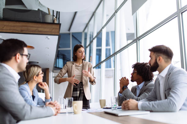 istock Female manager stands addressing team at board meeting 1144961596