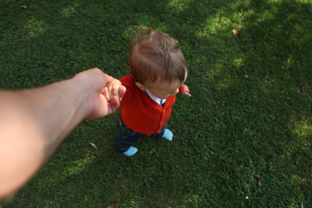 Mother´s point of view. Small boy holds the hand of his mother and looks to teh front about to start walking