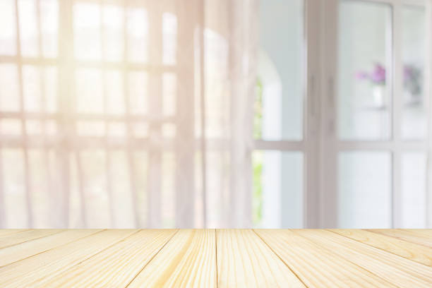 istock Empty wood table top with window curtain abstract blur background for product display 1144963863