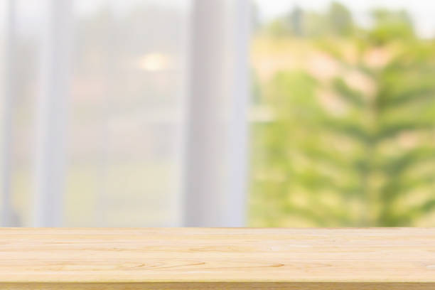 istock Empty wood table top with window curtain abstract blur background for product display 1144963867
