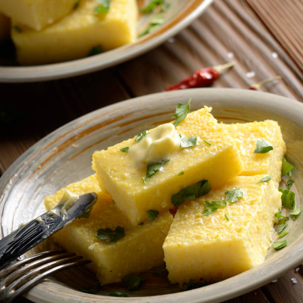 istock Polenta with butter and greens on clay dish on wooden rustic table 1144966436