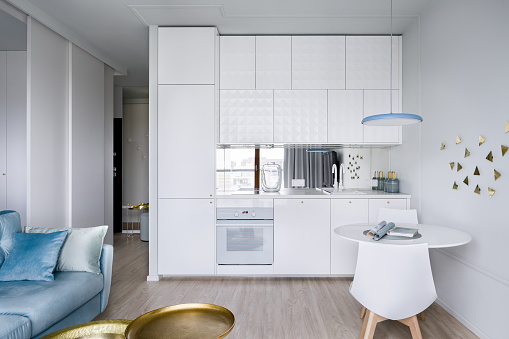 Contemporary apartment interior with functional, open white kitchen area