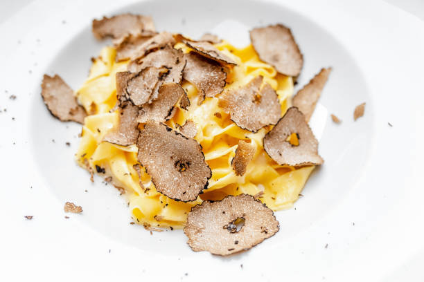 piatto di deliziosa pasta italiana con chips di funghi al tartufo, sul tavolo in ristorante di lusso. - edible mushroom mushroom ravioli basil foto e immagini stock