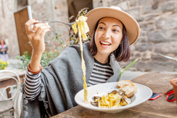 glückliche asiatische frau, die nudeln mit trüffel im italienischen restaurant im freien isst - asian cuisine lunch dinner food stock-fotos und bilder