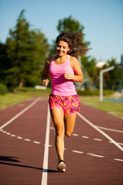 istock active young woman runs on atheltic track on summer afternoon 1144972163