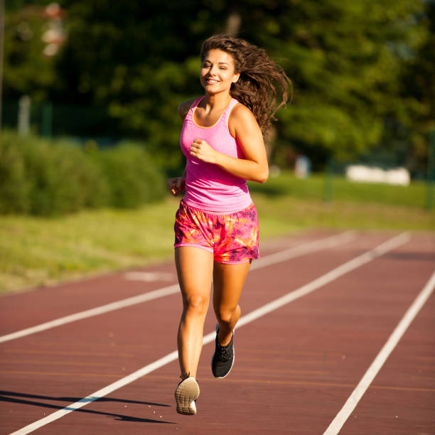 istock active young woman runs on atheltic track on summer afternoon 1144972189