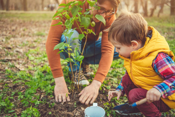 istock Family planting tree on Arbor day in springtime 1144977350