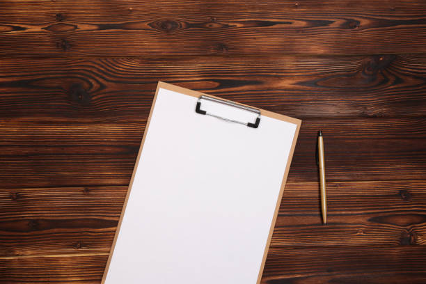 istock Clipboard with white sheet on wood background. Top view. - Image 1144980029