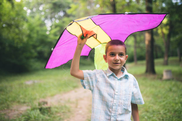 istock Happy and smiling boy playing in with kite outdoor 1144980095