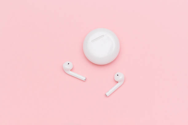 istock White wireless Bluetooth headphones and charging case on pink paper background. Template for text or your design. Flat lay Top view Copy space 1144980481
