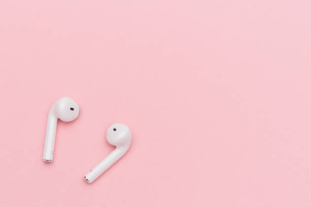 istock White wireless Bluetooth headphones on pink paper background. Template for text or your design. Flat lay Top view Copy space 1144980489