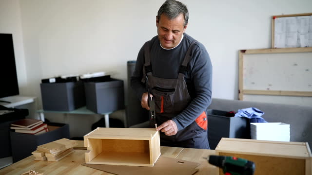 Mature man assembling wooden drawer