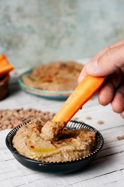 istock dipping carrot in a homemade lentil hummus 1144982132